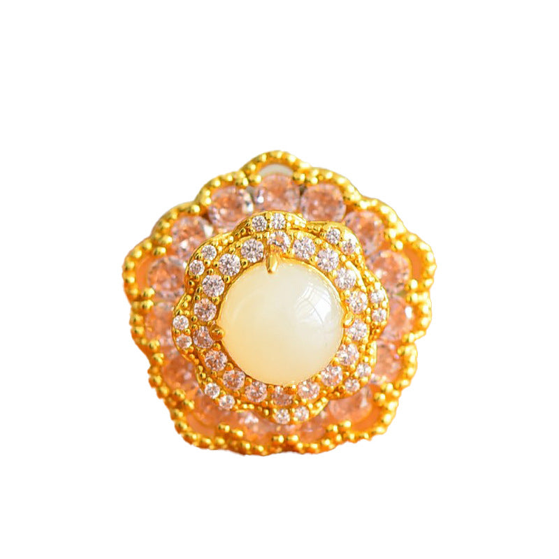 Jewelry item with a central pearl surrounded by gold and gemstone accents on a white background