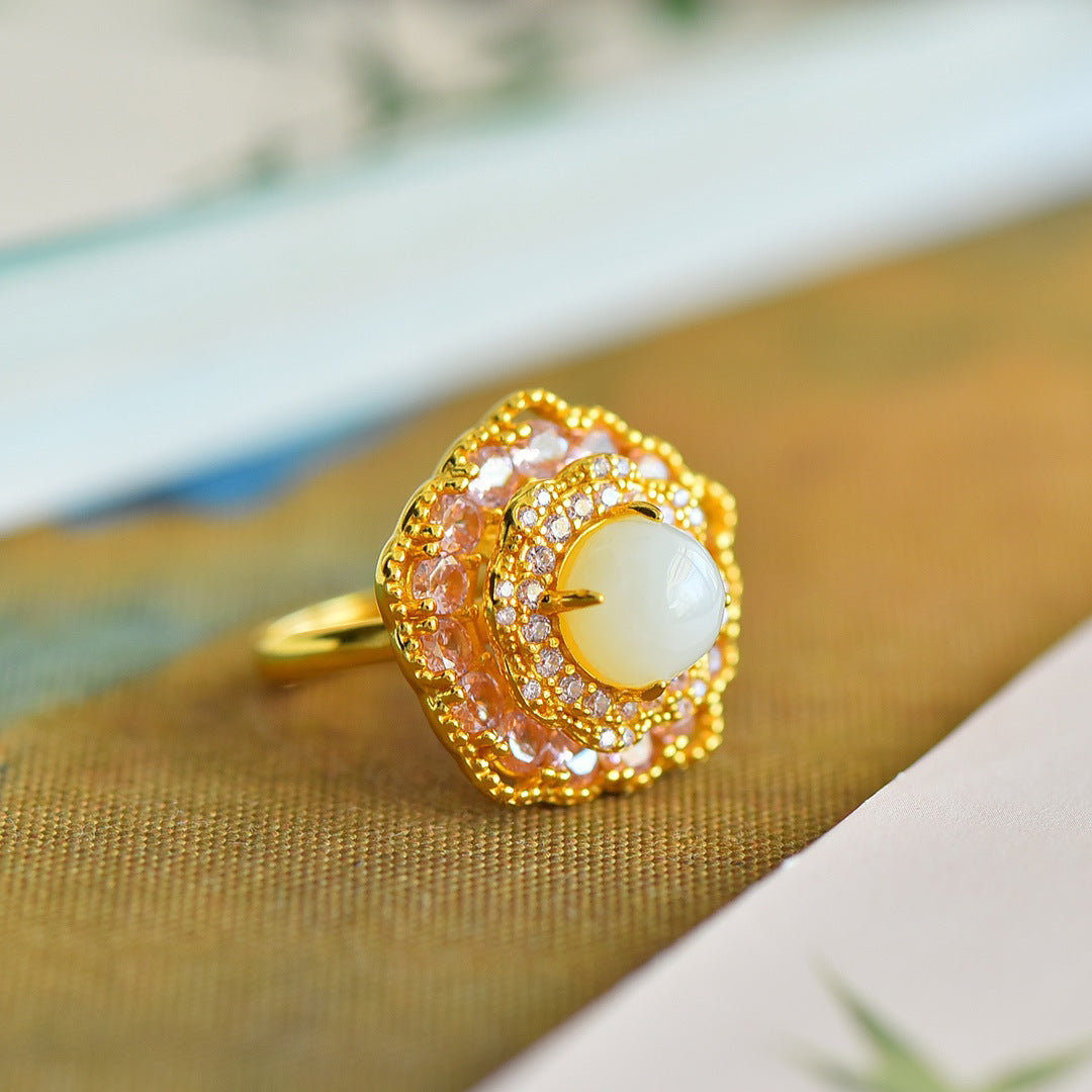 Gold ring with a central gemstone on a textured surface