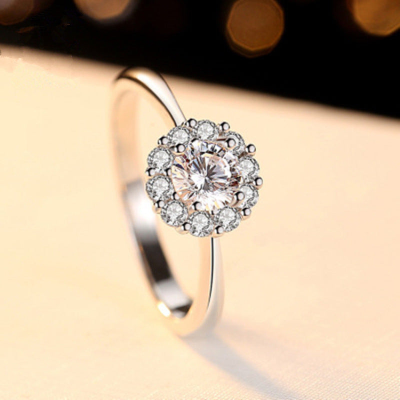 Silver ring with a diamond-like center on a blurred background