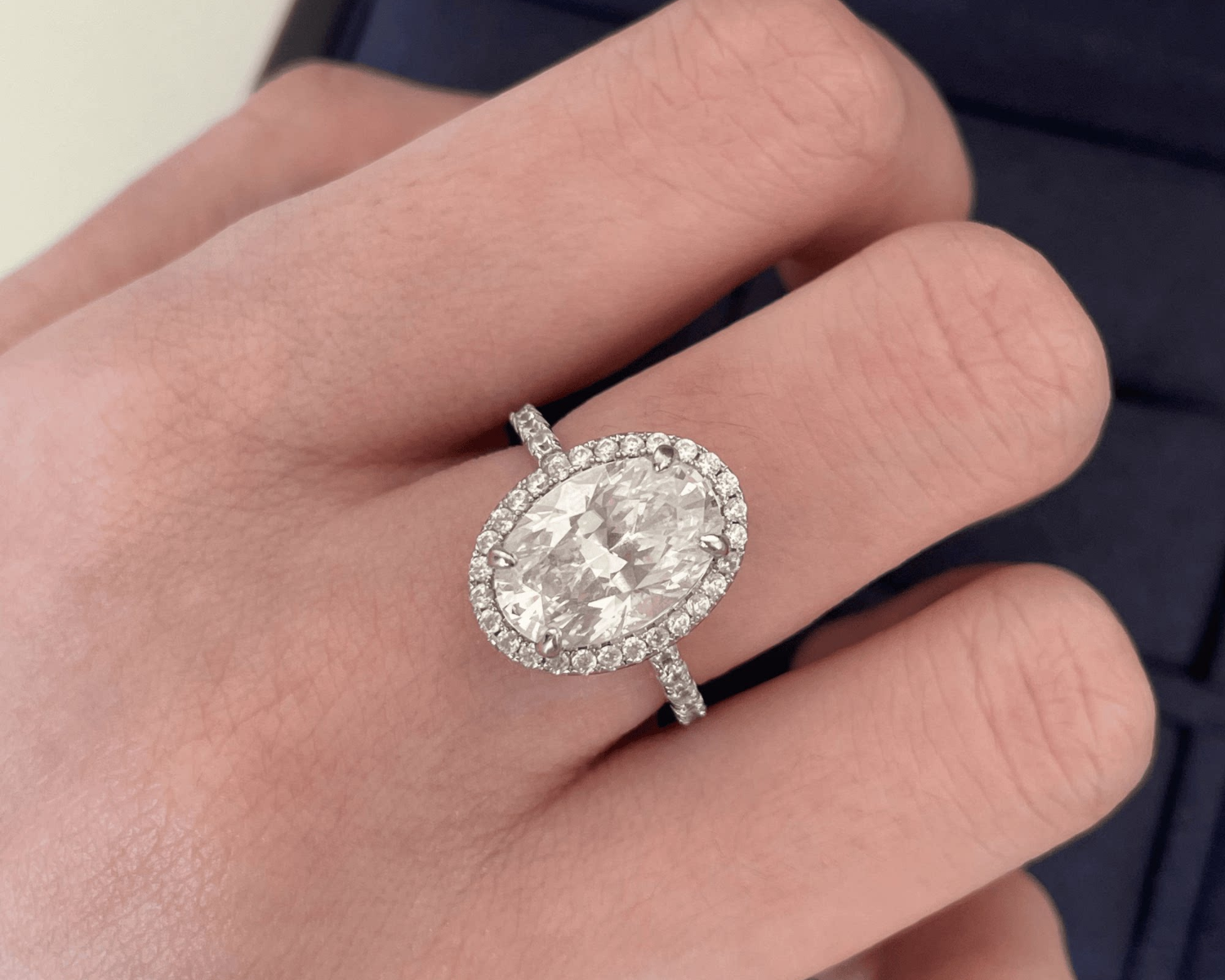 Diamond ring on a hand with a neutral background