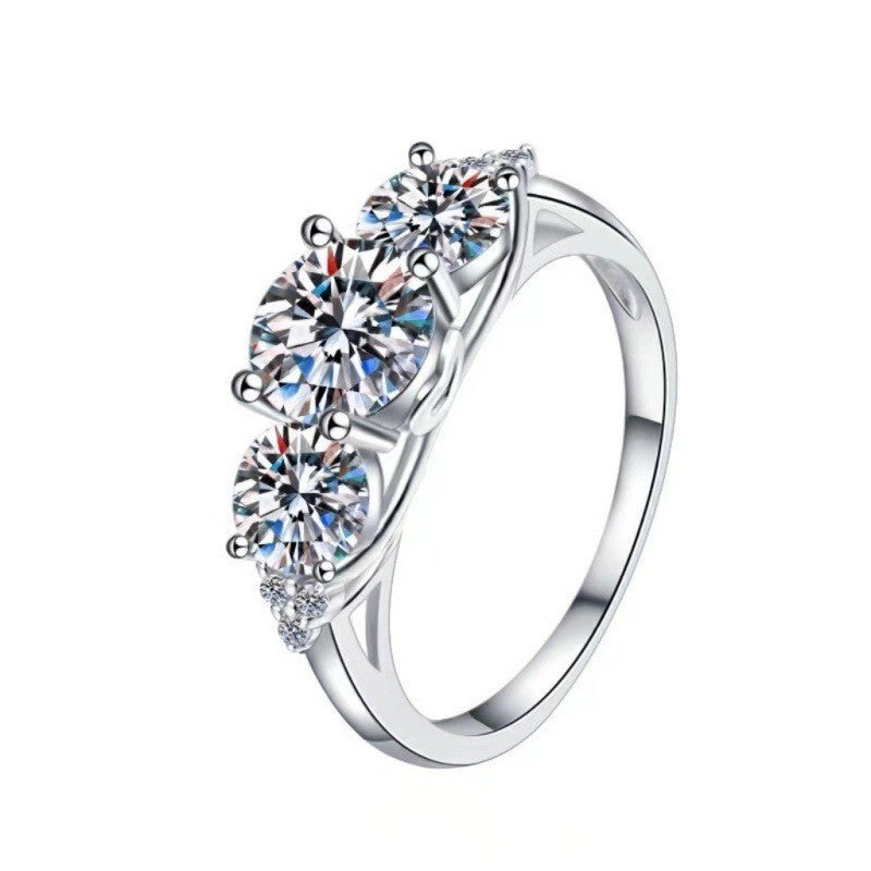 Silver ring with three round diamonds on a white background