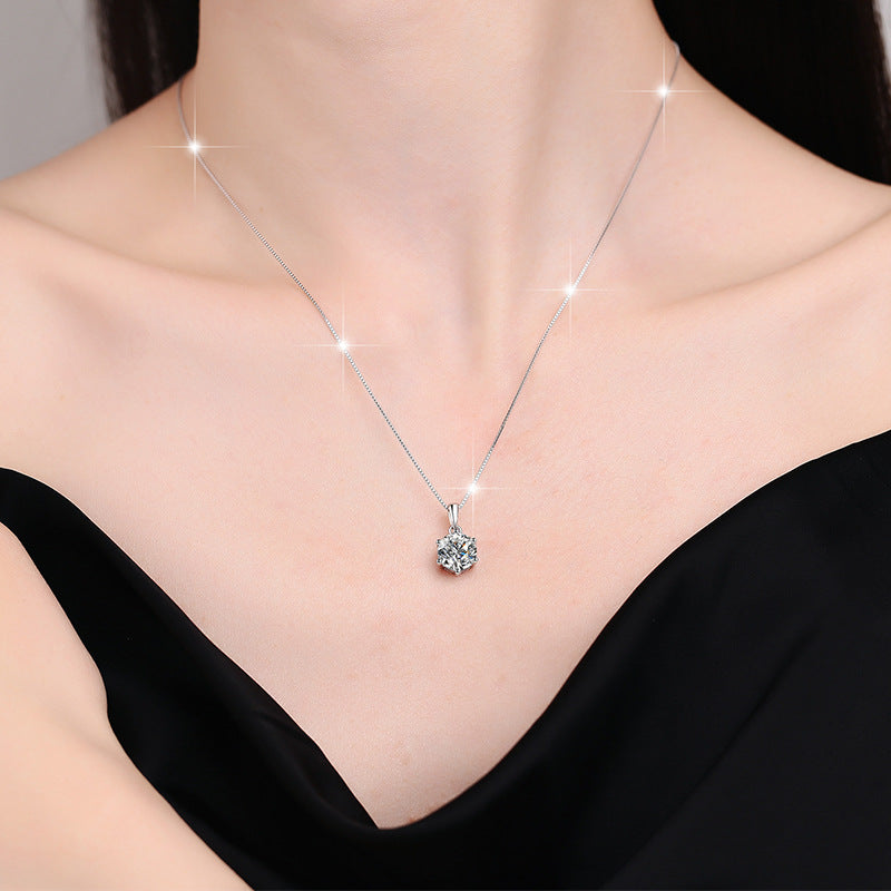 Silver necklace with a pendant on a model wearing a black top