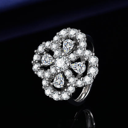 Silver ring with diamond flower design on a black background