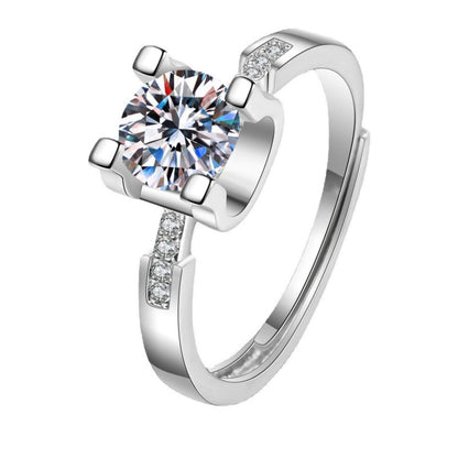 Silver ring with a large central gemstone and smaller stones on the band against a white background