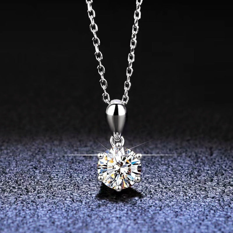 Silver necklace with a diamond pendant on a dark textured background