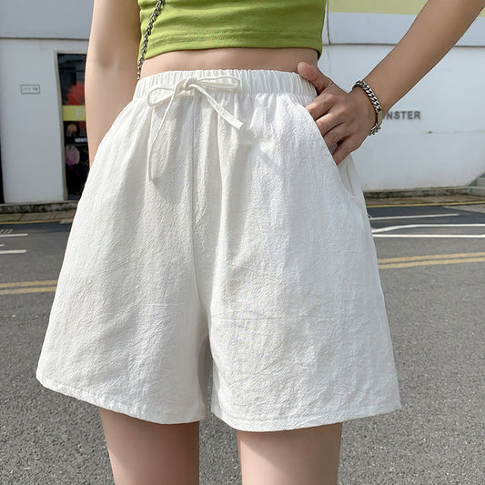 Person wearing white shorts and a green top on a street background