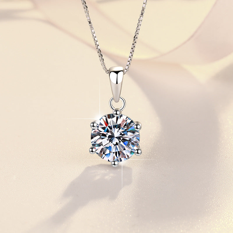Silver necklace with a large diamond pendant on a soft beige background