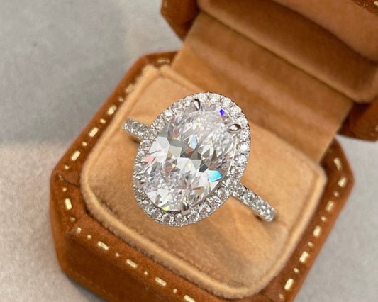 Diamond ring in an open brown velvet jewelry box on a light gray background