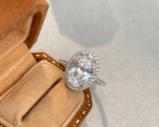 Diamond ring in a brown velvet box on a light gray background